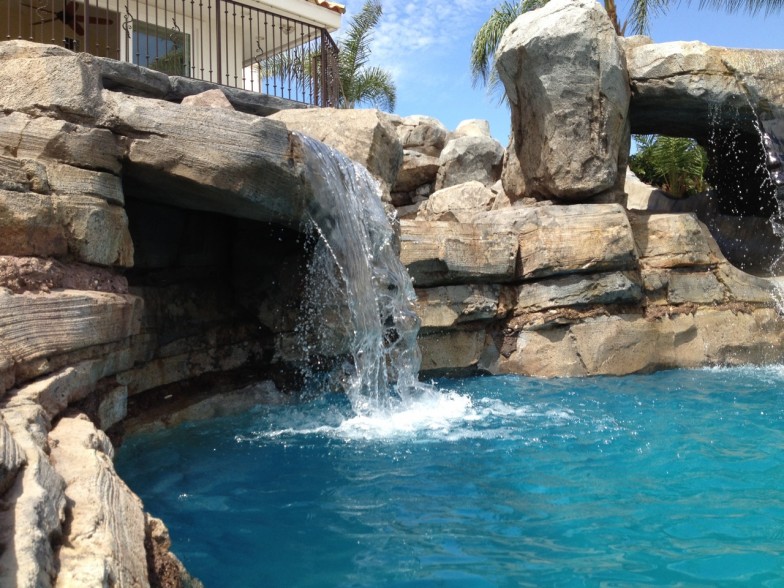 Pool with a custom waterfall, creating an environment to relax in.