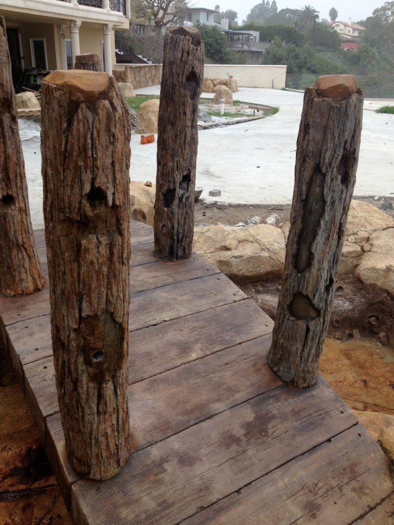 Wooden footbridge crossing over a serene stream, surrounded by lush greenery and tranquil natural beauty.